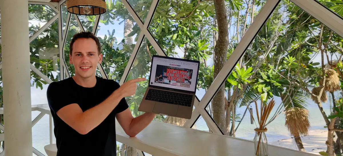 Ambroise Debret montre sur son laptop une présentation en 7 étapes pour devenir freelance à distance, dans un coworking vitré à Koh Phangan