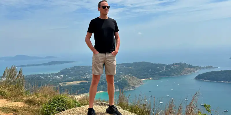 Ambroise Debret debout au sommet d’un point de vue face à la baie de Nai Harn, à Rawai en Thaïlande